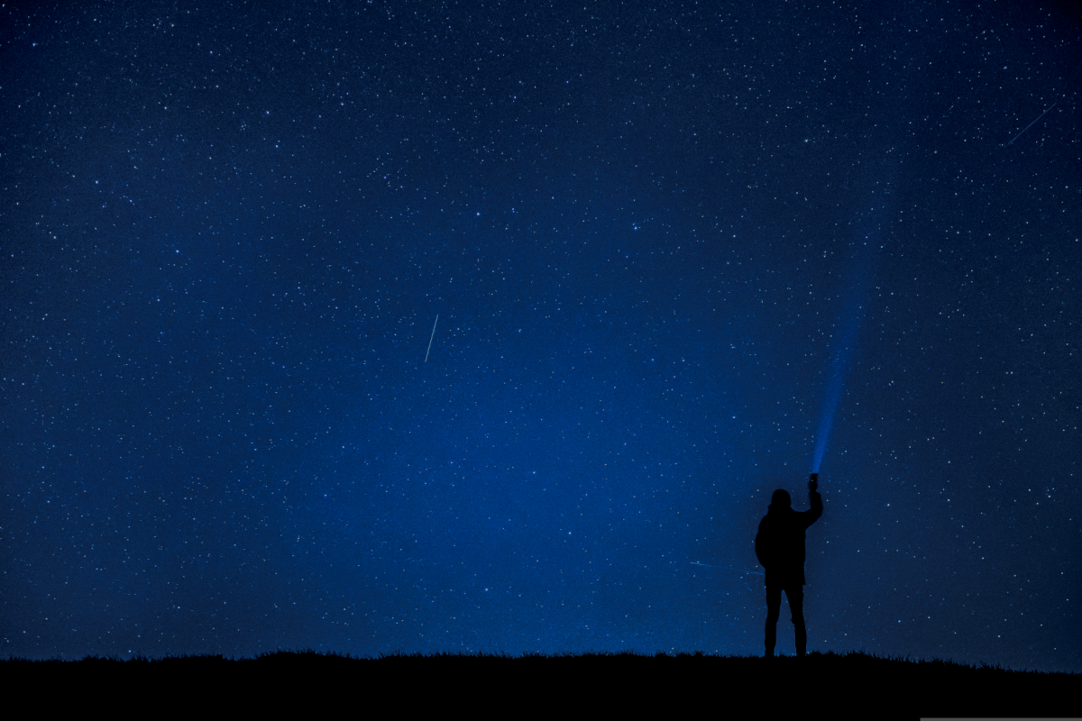 Foto di un astrofilo che guarda il cielo a occhio nudo